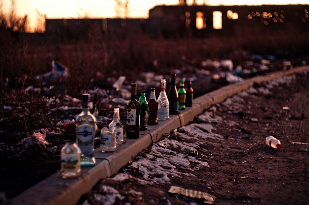 Alkoholflaschen aufgereiht auf dem Bürgersteig.